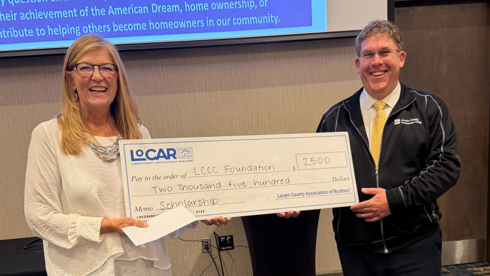 LoCAR REALTOR� Kim Guelker presents Jonathan Logue,  Director of Development for the Lorain County Community College Foundation the LoCAR Scholarship check.